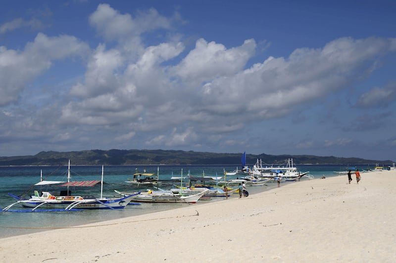 FILE PHOTO: Traditional boats line up the shore in a secluded beach on the island of Boracay, central Philippines January 18, 2016.    REUTERS/Charlie Saceda/File Photo