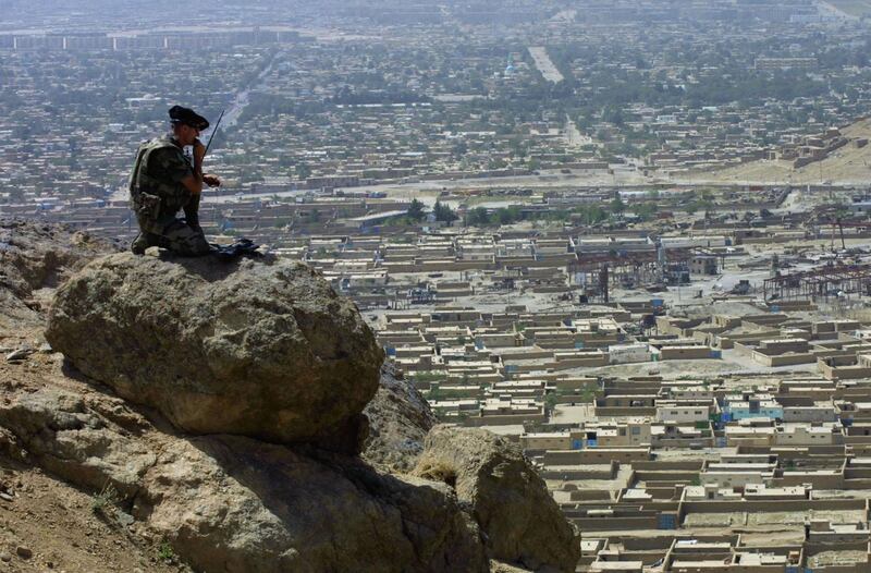 KABUL, AFGHANISTAN - AUGUST 3:  A French soldier from the 7th Mountain Regiment, part of the International Security and Assistance Force (ISAF) stands on a boulder overlooking Kabul during a patrol August 3, 2002 in Afghanistan. The ISAF has been patrolling Kabul since January 2002, working with the government and a new police force to prevent the violence and lawlessness that threatened to engulf the city after a U.S.-led coalition forced the Taliban from power.  (Photo by Natalie Behring-Chisholm/Getty Images)