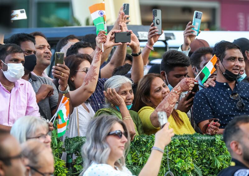 Visitors wave flags during India Day at Expo 2020 Dubai at Al Wasl Plaza.