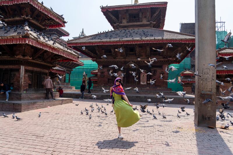 A tourist poses for a photo at Basantapur Durbar Square in Kathmandu. AP
