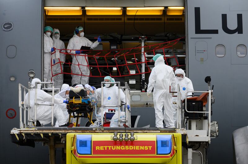 A coronavirus patient is transported by medical personnel to a German Air Force A310 MedEvac aircraft at Dresden International Airport.  AP