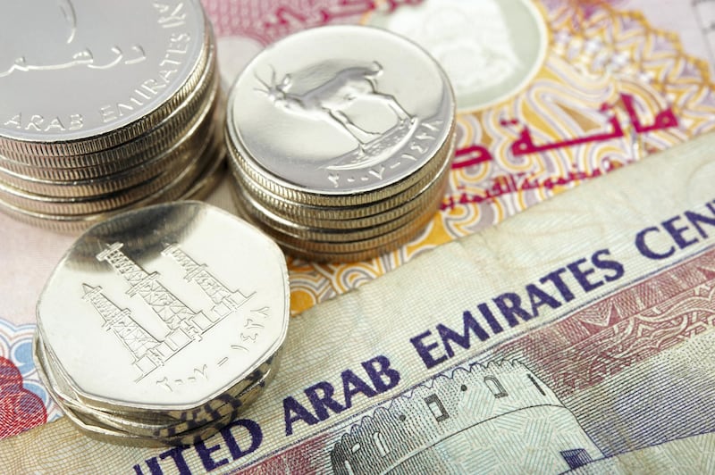 united arab emirates dirham banknote and coins. the coin depict arabian oryx and oil derricks.