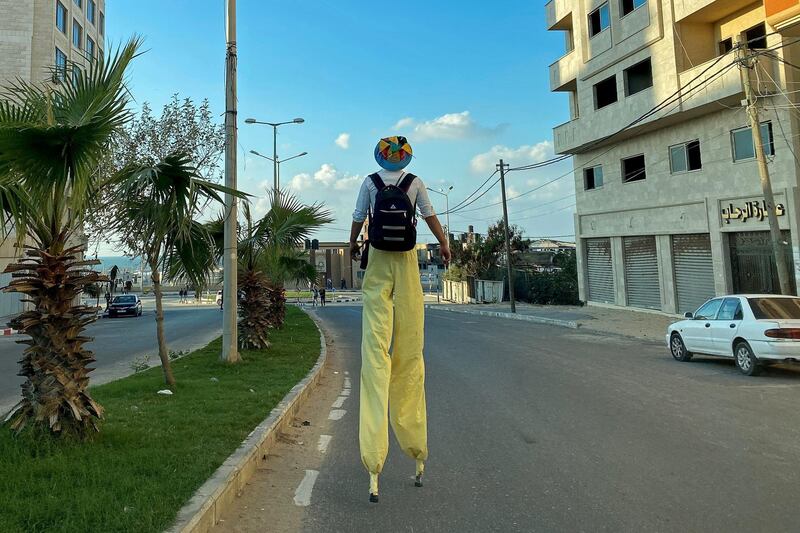 A Palestinian clown on stilts walks on a street amid the pandemic, in Gaza City. Reuters
