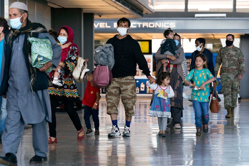 Families who made it out of Kabul walk through the terminal of Washington Dulles International Airport after arriving in the US. AP