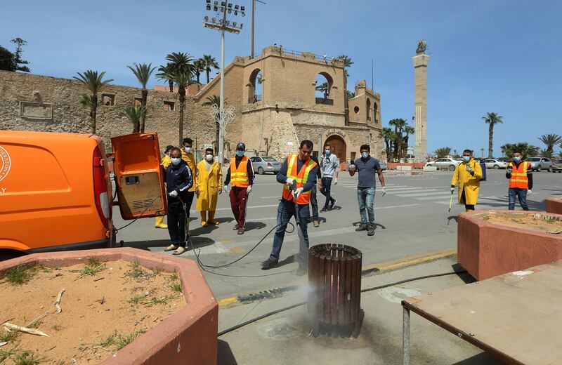 Libyan workers disinfect a street in the centre of the capital Tripoli on April 1, 2020, as a measure to stem the spread of the novel coronavirus that causes the COVID-19 disease, on April 1, 2020. / AFP / Mahmud TURKIA
