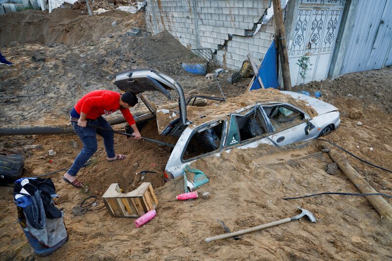 A Palestinian checks a car damaged by Israeli air strikes in Gaza city. Reuters