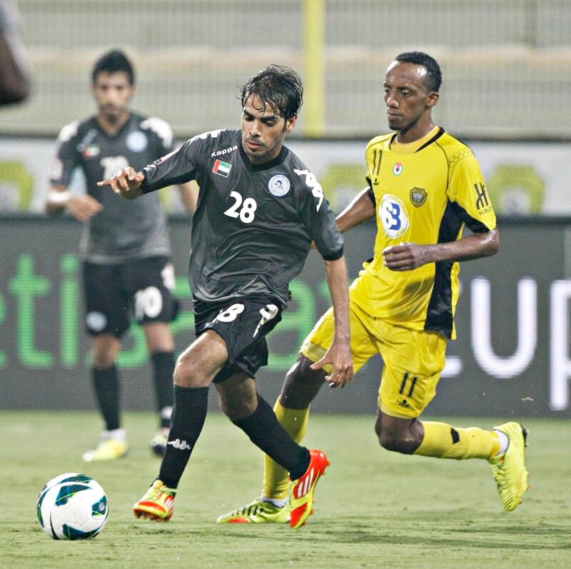 DUBAI, UNITED ARAB EMIRATES - October 10, 2012- AL Dhafra's Adel Almehrazi (28) keeps control of the ball from Al Wasl's Faisal Khalil (11) during first half football action in Zabell Stadium in Dubai City, Dubai October 10, 2012. (Photo by Jeff Topping/The National)