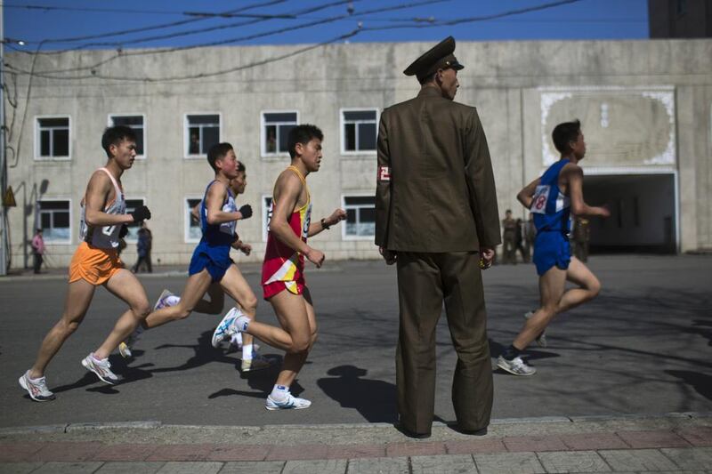Marathon runners pass by a North Korean soldier during the marathon in Pyongyang in 2013. David Guttenfelder/AP Photo