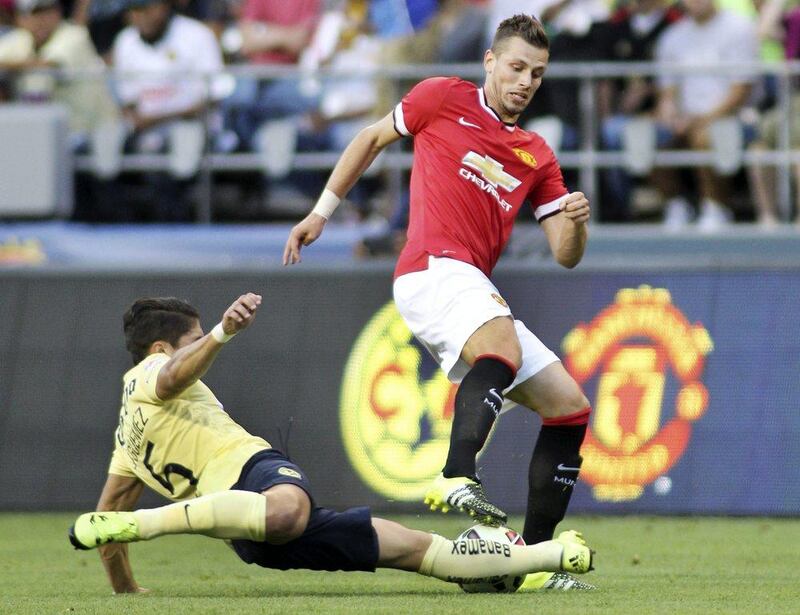 Manchester United's Morgan Schneiderlin tries to maintain control of the ball from a tackle by Club America's Javier Guemez during their pre-season friendly on Friday in Seattle. Anthony Bolante / Action Images / Reuters