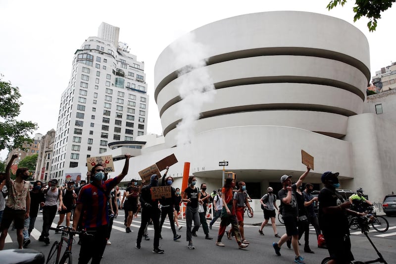 Protestors hold up signs while demonstrating in the street past The Guggenheim Museum in New York.  EPA