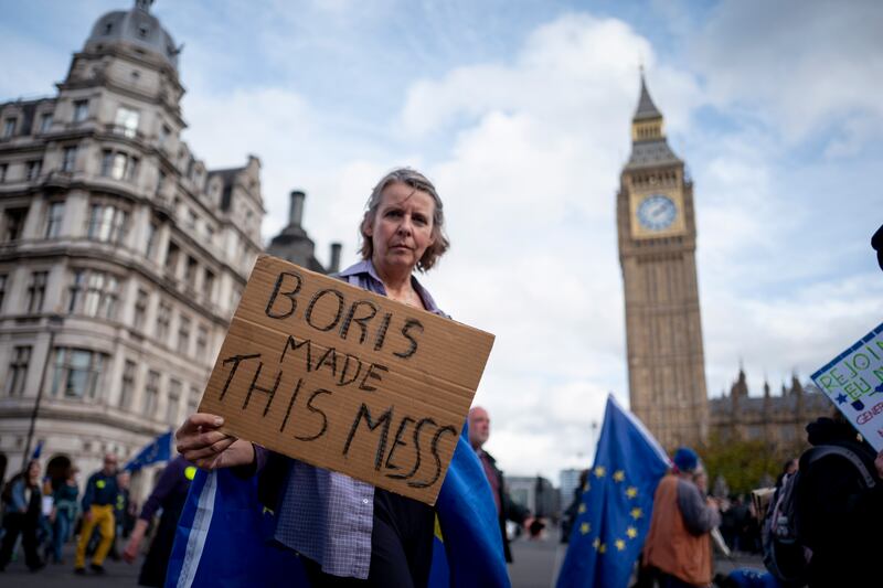 A Pro-EU campaigner holds a placard blaming former British Prime Minister Boris Johnson during a march to rejoin the European Union in London, on October 22. EPA