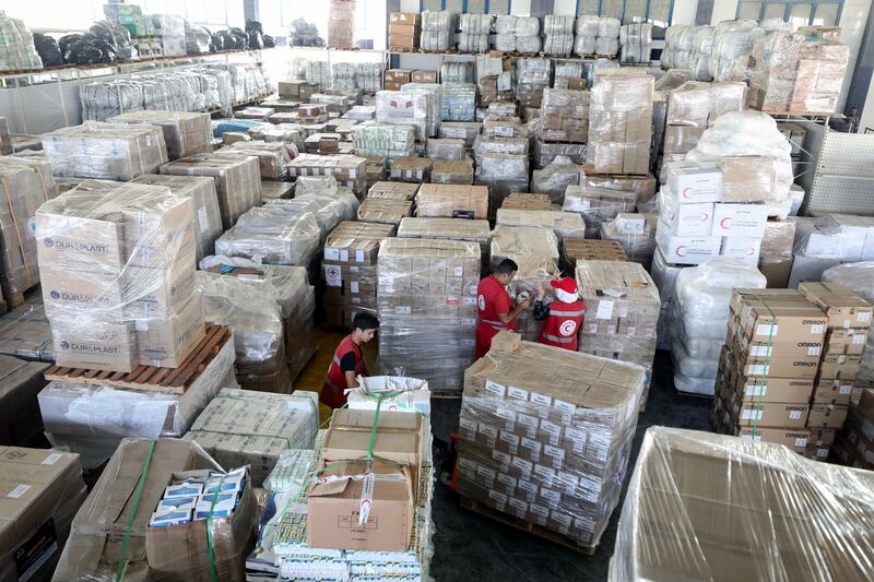 Egyptian Red Crescent workers and volunteers organise humanitarian aid bound for the Gaza Strip, at a warehouse in Arish, Egypt. EPA