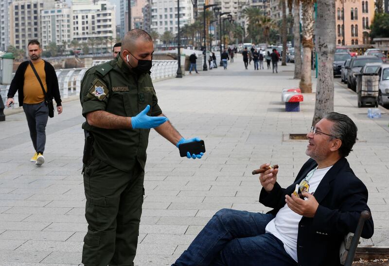 A municipal police officer, left, orders a man to leave the corniche, or waterfront promenade, along the Mediterranean Sea in Beirut. AP Photo