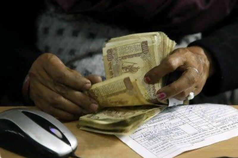 A cashier counts Indian rupee bank notes in Allahabad, India. AP Photo