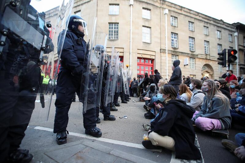 Demonstrators sit in front of police officers as the protest started peacefully in Bristol. Reuters