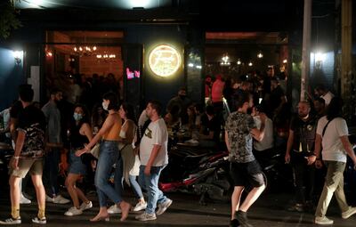People walk past a bar in Mar Mikhael neighborhood, an area that was damaged in last year's port blast, in Beirut Lebanon June 6, 2021. Picture taken June 6, 2021. REUTERS/Emilie Madi