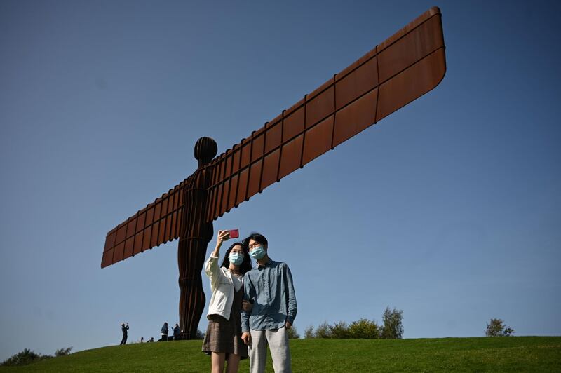 Visitors pose for photographs at Antony Gormley's 'Angel of the North' in Gateshead, northeast England. AFP
