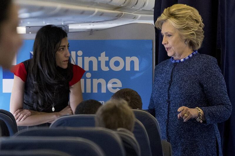 Hillary Clinton speaks with senior aide Huma Abedin aboard her campaign plane. The longtime Clinton aide is at the centre of a renewed FBI email investigation. (AP Photo/Andrew Harnik)