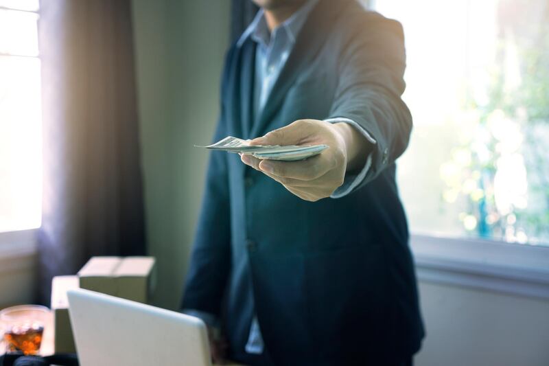 selective focus hand of Business man offer money us dollar  for client