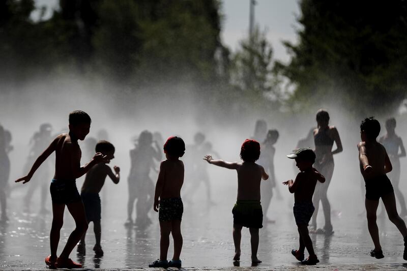 Children play in a fountain during a hot summer day, in Madrid, Spain.  EPA