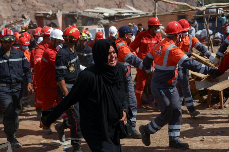 A woman grieves as rescue workers carry her husband's body from rubble in Talat N'Yaaqoub. Reuters