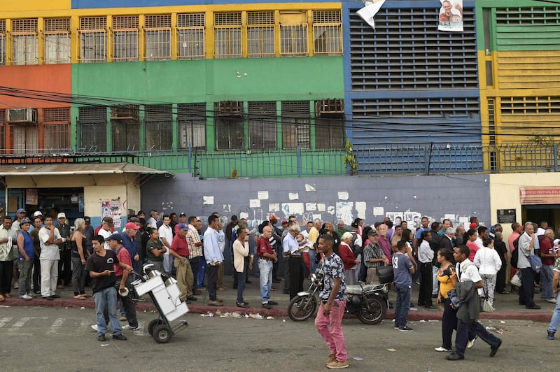 Venezuelans queue outside a polling station as they wait to cast their vote during the presidential elections in Caracas. Federico Parra / AFP
