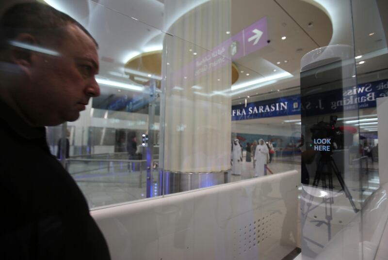 A passenger walks through the Smart Tunnel at the airport in Dubai, United Arab Emirates, Wednesday, Oct. 10, 2018. Passport control looked a little different today in Dubai at the world's busiest airport for international travel. That's because Dubai International Airport debuted a new "smart tunnel." (AP Photo/Kamran Jebreili)