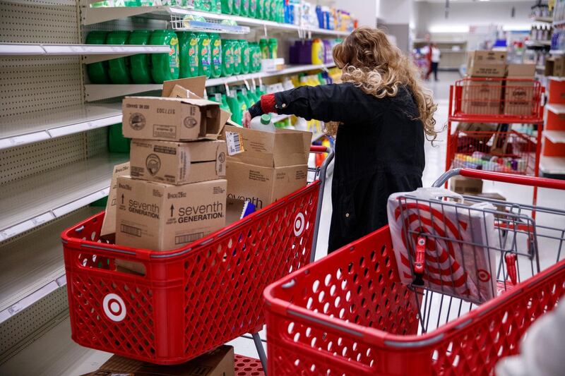 epa08289519 A shopper looking for hand sanitizer looks through boxes at a Target in Alexandria, Virginia, USA, 12 March 2020. The COVID-19 coronavirus pandemic and the travel ban announced by US President Trump on 11 March have sparked shoppers to clean the shelves of household necessity items.  EPA/SHAWN THEW