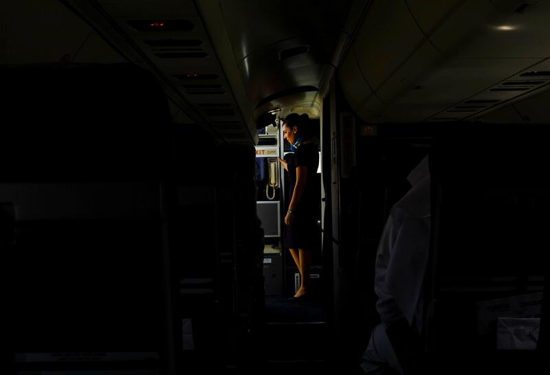 Dubai, United Arab Emirates - August 01 2013 - An airhostess waits for instructions to exit the new Rotana Jet after it landed at Dubai International Airport. It that operates as a commuter flight daily between Abu Dhabi and Dubai. Four National reporters raced from Abu Dhabi to Dubai using various modes of transport to see which vehicle took the least time between two cities.  (Razan Alzayani / The National) 