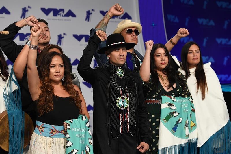 Taboo, centre, and Native American musicians raise their fists in protest of the Dakota Access Pipeline. Jordan Strauss / Invision / AP