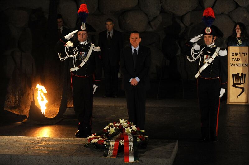 Mr Berlusconi, centre, stands solemnly after laying a wreath at the Hall of Remembrance at the Yad Vashem Holocaust Memorial in Jerusalem in 2010. AFP