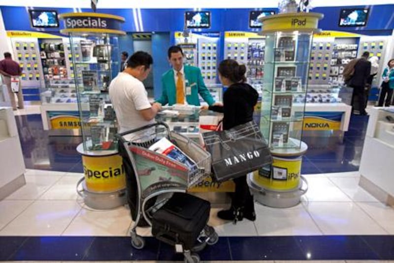 A sales clerk helps customers at the duty-free electronics store in Dubai's Airport Terminal 3.