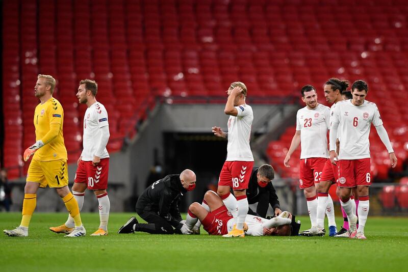 Kasper Dolberg of Denmark is tended by medical staff after being tackled by Harry Maguire . Getty