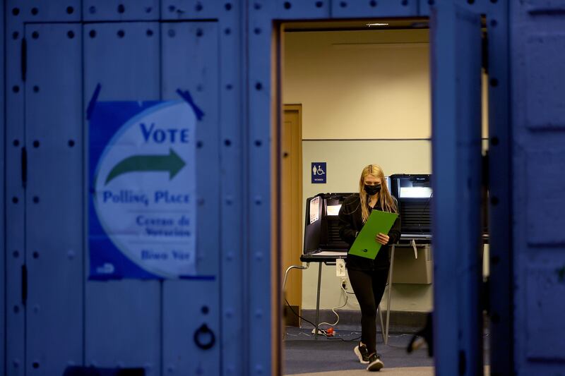 A voter carries an election ballot to the voting machine at a polling station in Miami, Florida. AFP