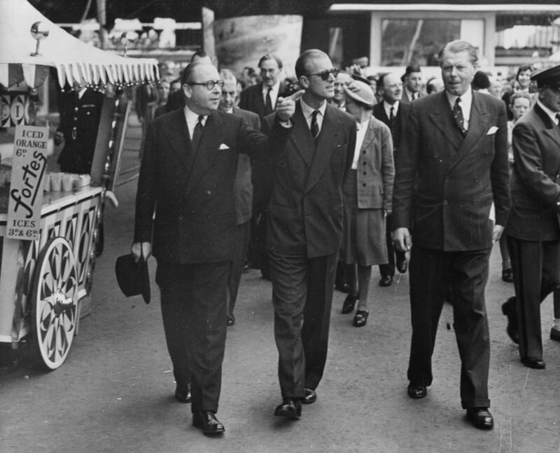 Prince Philip, the Duke of Edinburgh (centre), walking with Sir Gerald Barry (left), Director General of the South Bank Festival, with the latter pointing out some of the features of the Festival as they take a tour, London, July 27th 1951. (Photo by Don Price/Fox Photos/Getty Images)