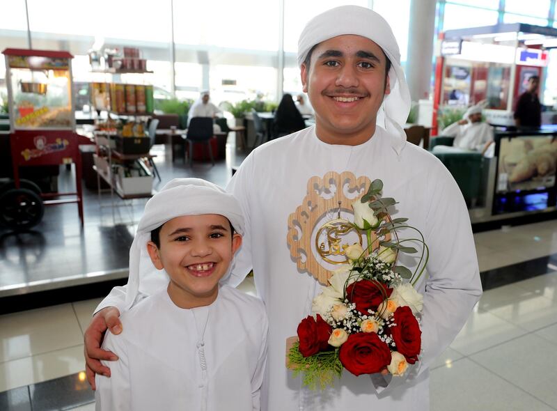 Abu Dhabi, United Arab Emirates - August 15, 2019: Hamdan 15 and Rakan 9 greet their father Mohammed from the Hajj pilgrimage. The pilgrims will be returning following the Eid Al Adha holiday. Thursday the 15th of August 2019. Abu Dhabi International Airport, Abu Dhabi. Chris Whiteoak / The National