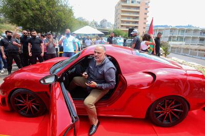 Lebanese-born Palestinian businessman Jihad Mohamad, arrives in the "Quds Rise", the first ever electric car produced in Lebanon, during an unveiling ceremony in Khaldeh, south of the capital Beirut, on April 24, 2021. The locally-made electric car made its debut in a double first for the Mediterranean country that has never manufactured automobiles and is wracked by economic crisis and power cuts. / AFP / ANWAR AMRO
