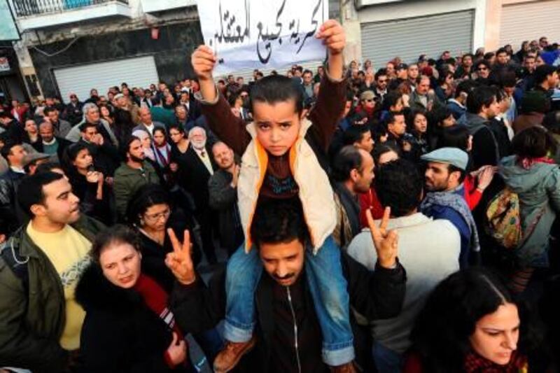 A child holds a placard bearing a slogan which translates as " Freedom for all the prisoners" during a demonstration in Tunis on January 8, 2011 in support of prisoners held after clashes between demonstrators and police in December 2010 in the town of Sidi Bouzid, some 265 Kms from Tunis.  The United States raised concerns with Tunisia about its handling of political unrest as well as its apparent "interference" with the Internet, senior US officials said.   AFP PHOTO/FETHI BELAID
 *** Local Caption ***  008141-01-08.jpg