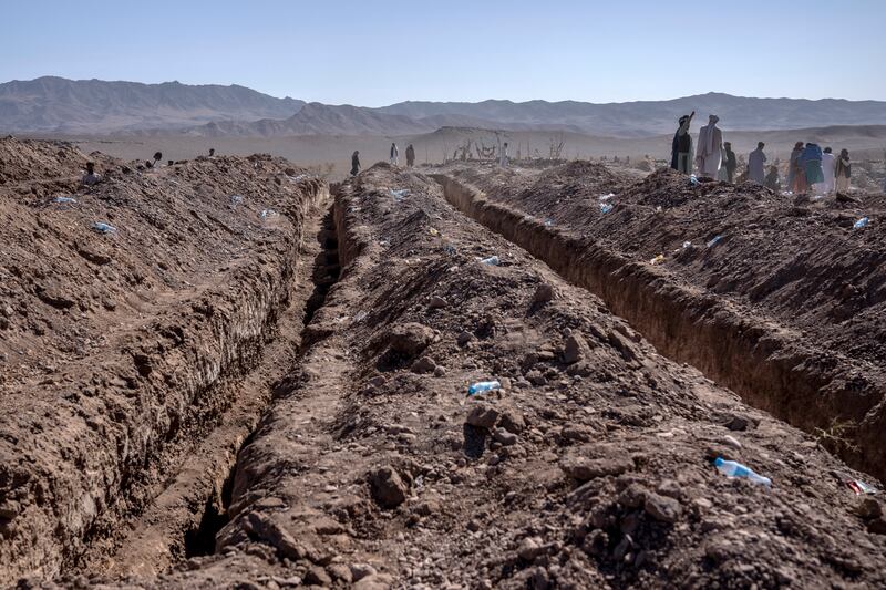 Afghans dig a trench to bury the dead in the Zenda Jan district in Herat province. AP