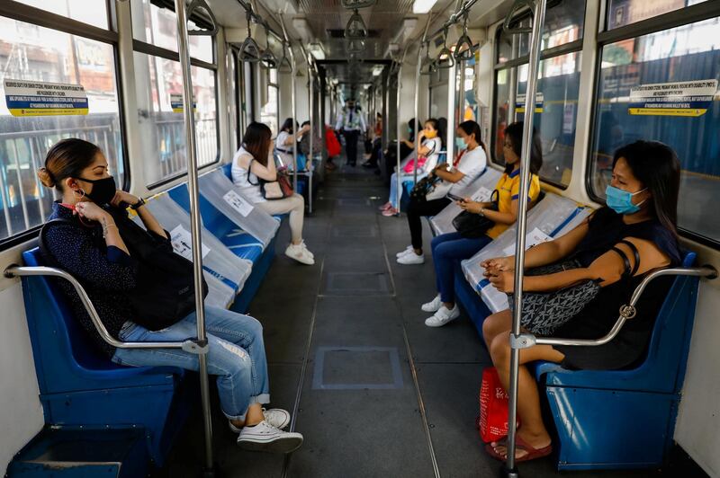 Passengers sit in between social distancing markers on the first day of train operations since the lockdown.  Reuters