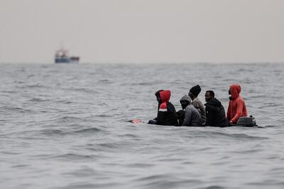 Migrants sit onboard a boat navigating in agitated waters between Sangatte and Cap Blanc-Nez (Cape White Nose), in the English Channel off the coast of northern France, as they attempt to cross the maritime borders between France and the United Kingdom on August 27, 2020. - The number of migrants crossing the English Channel -- which is 33,8 km (21 miles) at the closest point in the Straits of Dover --  in small inflatable boats has spiralled over the summer of the 2020. According to authorities in northern France some 6,200 migrants have attempted the crossing between January 1 and August 31, 2020, compared with 2,294 migrants for the whole of 2019. (Photo by Sameer Al-DOUMY / AFP)