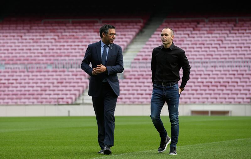 Andres Iniesta, right, and Josep Maria Bartomeu walk across the Camp Nou turf. Manu Fernandez / AP Photo