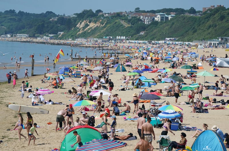 People relax on the beach during a hot summer day in Bournemouth, southern England. The UK's Met Office issued its first amber extreme heat warning on Monday, saying unusually high temperatures were expected over southern and western areas of England and Wales.