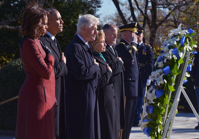 US president Barack Obama (second from left), First Lady Michelle Obama (left) along with former president Bill Clinton and former secretary of state Hillary Clinton take part in a wreath-laying ceremony in honour of the late 35th president John F. Kennedy at Kennedy's gravesite in Arlington National Cemetery. Mandel Ngan / AFP

