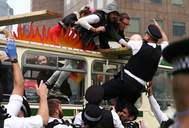 Police officers try to reach Extinction Rebellion demonstrators to remove them from the roadblock by London Bridge during a protest. Reuters