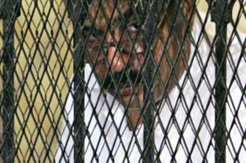 Hisham Talaat Moustafa, the former chairman of the Talaat Moustafa Group, stands behind bars at a court in Cairo.
