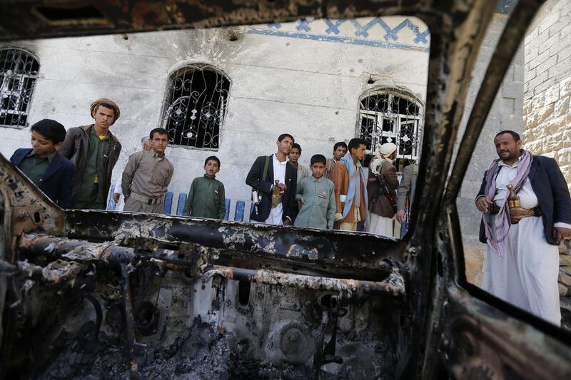 People look at a vehicle destroyed during a police raid on a hideout of Al Qaeda militants in the Arhab region, north of the Yemeni capital Sanaa. Khaled Abdullah / Reuters