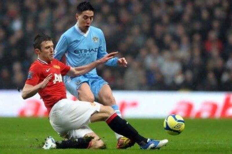 United's Michael Carrick, left, tackles Manchester City's French midfielder Samir Nasri, who was signed from Arsenal in the summer. Paul Ellis / AFP