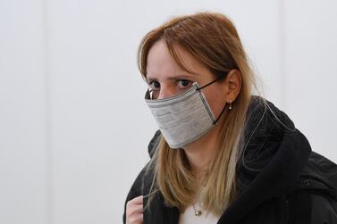 A woman wearing a face mask arrives at Heathrow Airport in London, Britain, 24, January 2020. The UK is to begin monitoring direct flights from China to stem the spread of the coronavirus in Britain. EPA