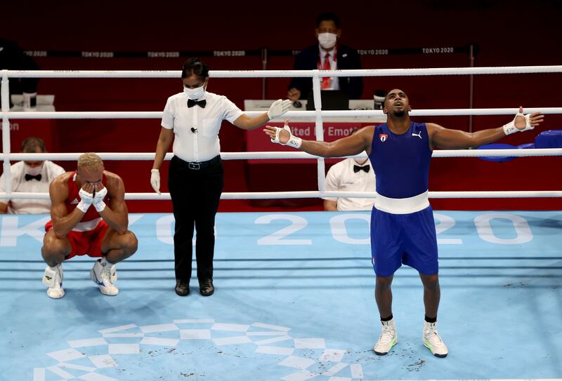 Mixed emotions ... gold medallist Arlen Lopez Cardona of Cuba, in blue, and Benjamin Whittaker of Britain after their light heavyweight fight at the Tokyo Olympics.